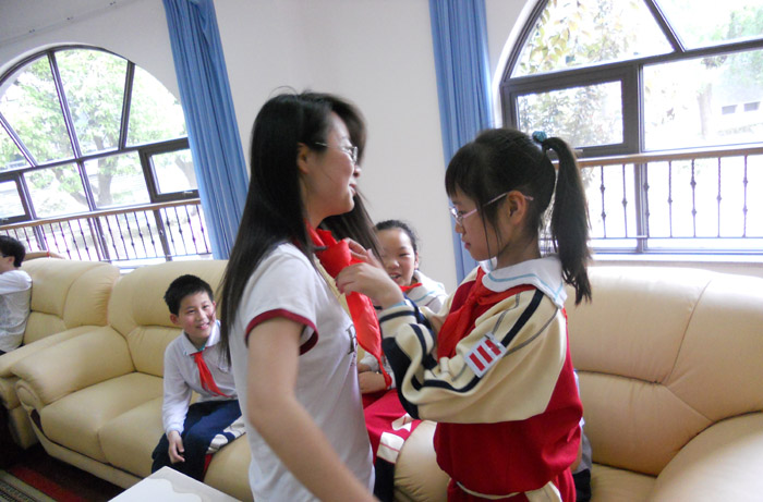 小学生为万象城官网志愿者系红领巾